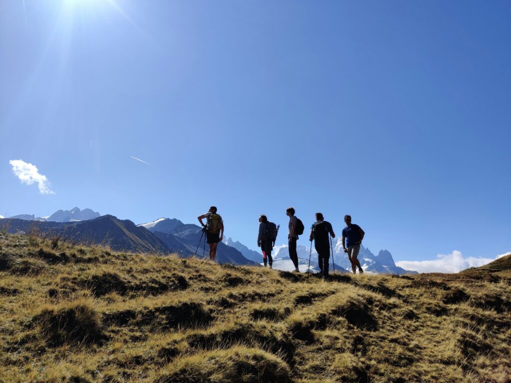 Cinq personnes en randonnée dans les Alpes suisses, pour une pause de déconnexion numérique avec Bas Les Masques