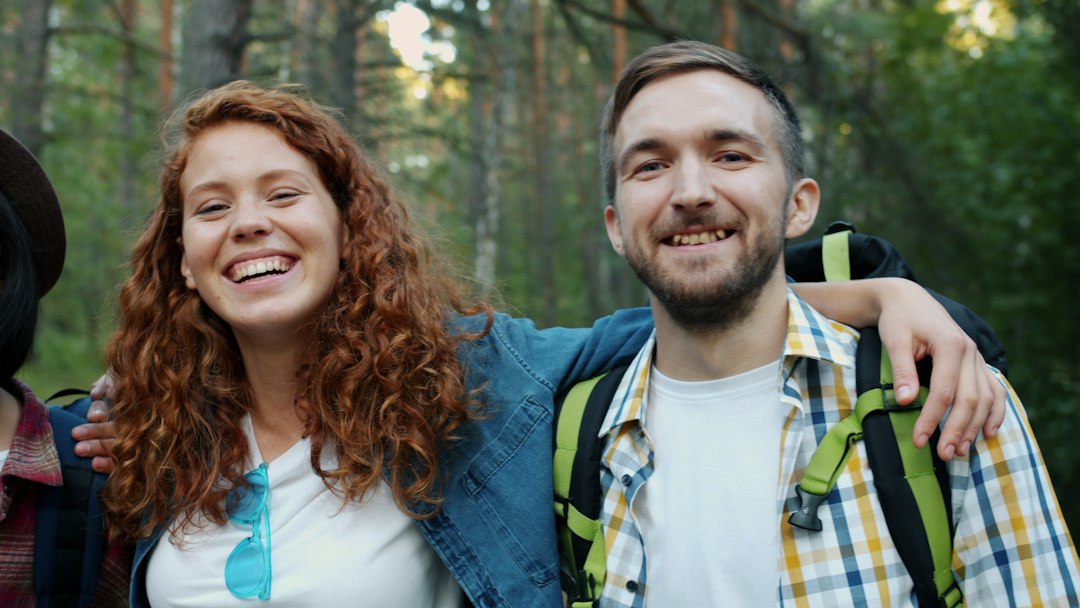 Deux adultes sourient pendant une randonnée en forêt — photo d’ambiance.
